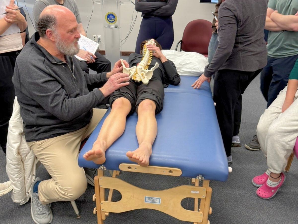 Dr. Sandweiss demonstrating with a spine model at the treatment table
